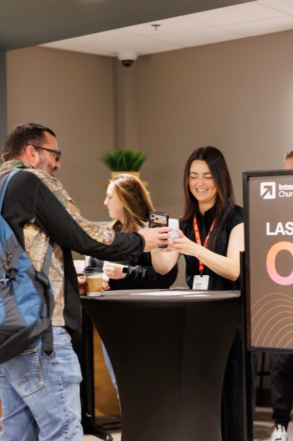 Team member scanning a phone at check-in